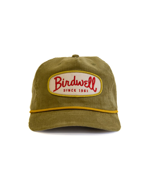 The Potato Patch Cord Snapback - Olive is an unstructured olive green 5-panel corduroy hat with a yellow trim and a front patch that says 