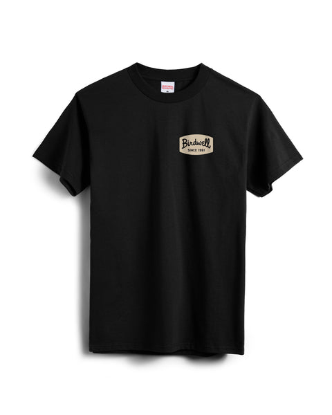 The Herald T-Shirt - Black is a heavyweight, garment-dyed tee with short sleeves and a small beige 