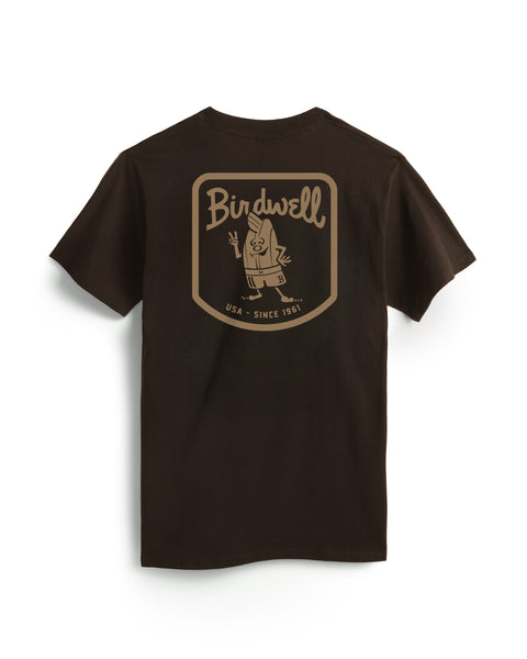 The Herald T-Shirt - Java is a black, garment-dyed heavyweight cotton tee with a large tan cartoon bird in swim trunks flashing two fingers on the back, and “Birdwell USA - Since 1961” above and below the graphic.