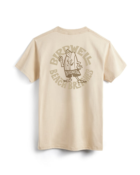 The Rounder T-Shirt - Cream is a heavyweight, garment-dyed tee with short sleeves, featuring a large back graphic of a cartoon character holding a surfboard and waving, with “Birdwell Beach Britches” arched around the design.