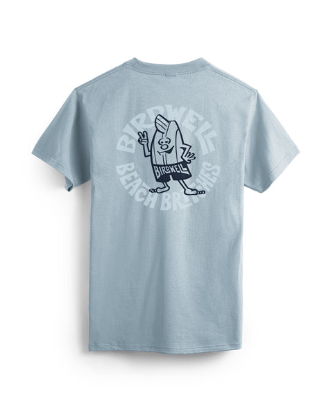 The Rounder T-Shirt - Arctic Blue is a light blue, garment-dyed tee with a cartoon character holding a surfboard and waving, plus bold “BIRDWELL BEACH BRITCHES” text on the back.