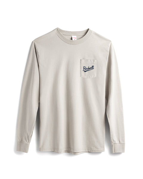 The Baller Long Sleeve Pocket T-Shirt in Cement is a heavyweight beige cotton shirt, made in the USA, featuring a left chest pocket and 