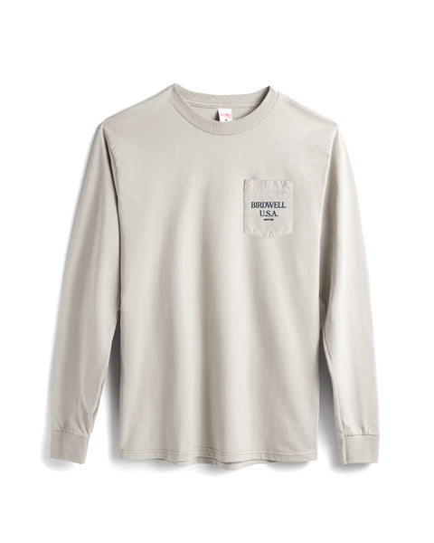 The Tourist Long Sleeve Pocket T-Shirt - Cement is a light beige cotton heavyweight long-sleeve tee with a left chest pocket and 