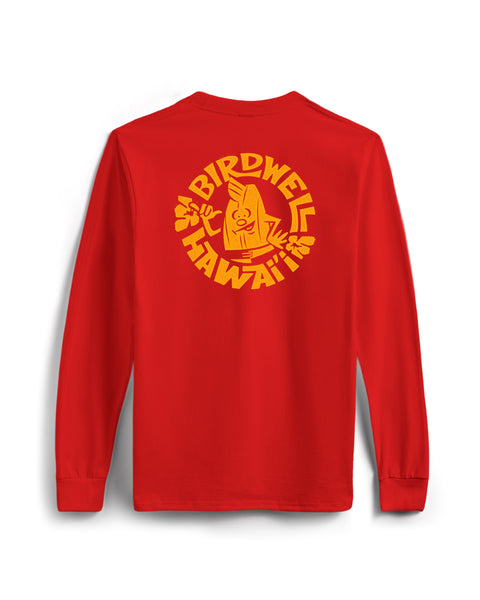 The Shaka Long Sleeve Pocket T-Shirt - Tomato is a red, garment-dyed cotton long sleeve tee featuring a yellow cartoon surfer, BIRDWELL HAWAII text, and two hibiscus flowers on the back. Made in the USA for comfort and style.