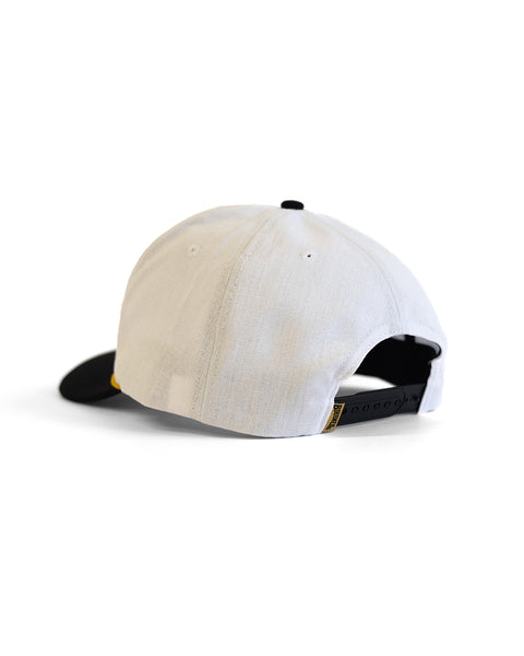 The Trademark Hemp Snapback - White/Black is a 5-panel cap featuring a white crown, black curved brim, and black adjustable strap, shown from the rear on a white background.