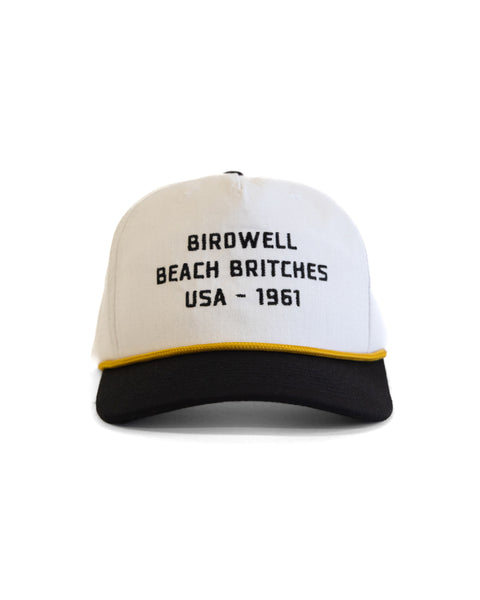 The Trademark Hemp Snapback - White/Black is a 5-panel cap with a white crown, black brim, yellow trim, and 