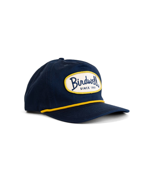 The Potato Patch Twill Snapback - Navy is a navy blue, 5-panel, high-crown cap featuring a yellow and white 