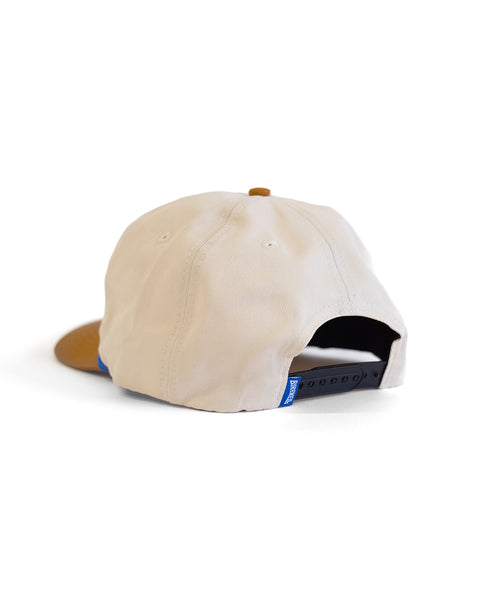 The Potato Patch Twill Snapback - Bone/Brown is a beige 5 panel hat with a brown brim, shown from the back on a plain white background. It features a high crown, black adjustable strap, and a small blue tag near the strap.