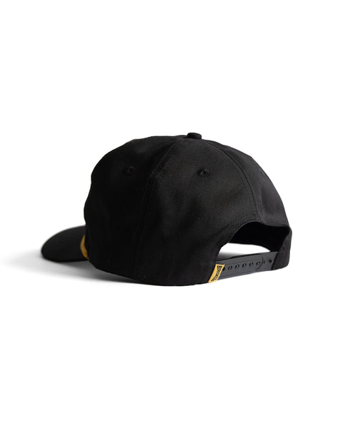 The Potato Patch Twill Snapback - Black is a 5 panel hat with an adjustable snapback strap and a small yellow tag near the closure, displayed from the back on a plain white background.