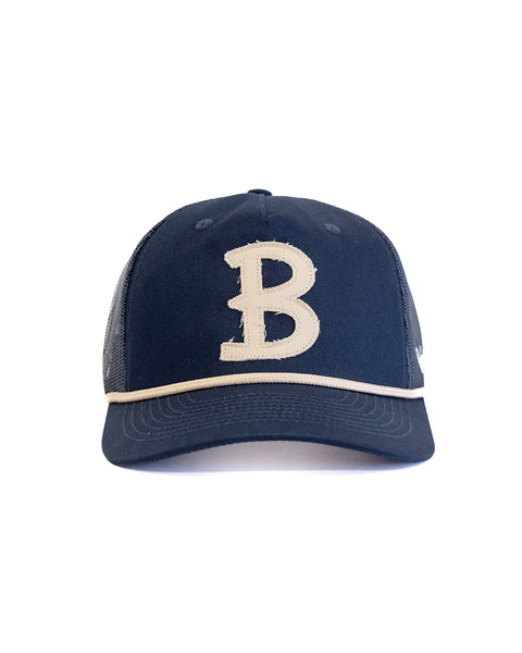 The Big B Twill Snapback - Navy is a 5-panel hat featuring a large cream letter B on the front and a mesh back, offering classic style and comfort.