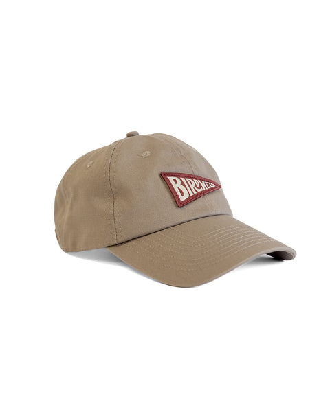 The Daddy Twill Hat - Sand is a tan cotton dad hat with a curved brim and a red patch on the front that says BROKEN in white. Its unstructured design provides casual style and comfort for everyday wear.