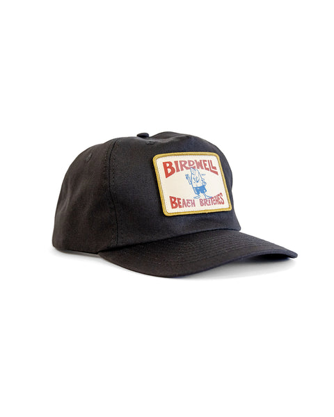 The OG Twill Snapback - Black is a black cotton snapback hat with a front rectangular patch displaying 