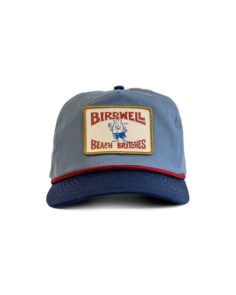 The OG Twill Snapback - Federal Blue/Navy is a high-crown blue cotton twill hat with a red and gold front patch featuring “Birdwell Beach Britches” and a cartoon bird in swim trunks.