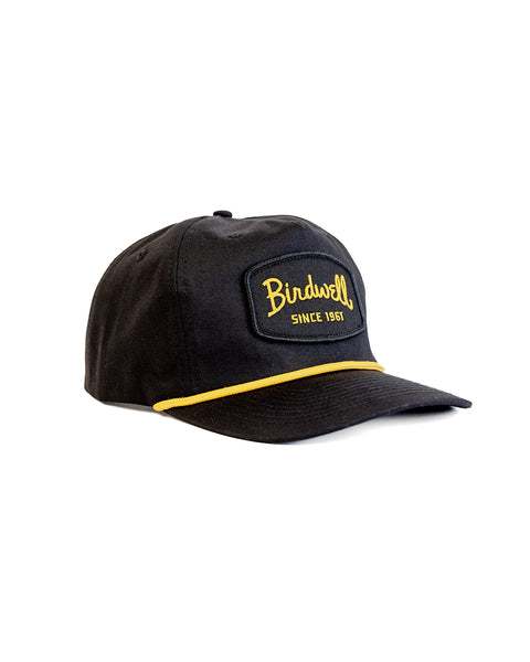 The Shield Twill Snapback - Black is a 5 panel hat featuring 
