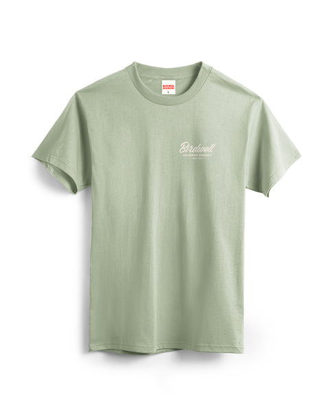 The Daydreamin Birdie T-Shirt in Desert Green is a garment-dyed cotton tee with short sleeves, featuring 