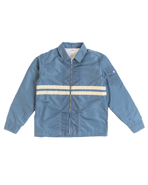 The Comp Jacket 25 in Federal Blue/Bone features SurfNyl durability, zip-up front, two white chest stripes, pointed collar, and a buttoned left sleeve pocket—American-made quality you can trust.