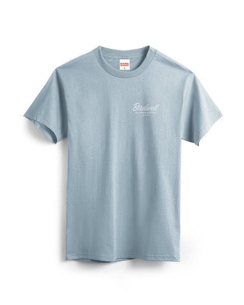 The Daydreamin Birdie T-Shirt in Arctic Blue is a 100% cotton heavyweight short-sleeve tee with a small white Bridwell logo and text on the left chest, shown flat on a white background.