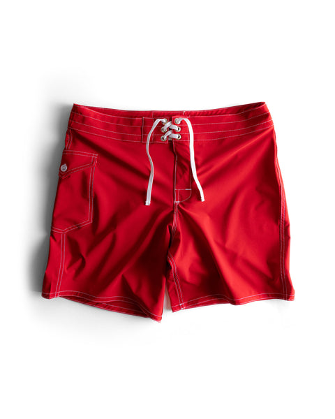 808 SurfStretch Side Pocket Boardshorts in red, featuring a white drawstring, front metal grommets, side pocket with button flap, and white stitching, are laid flat on a white background.
