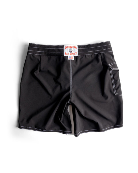 Black 808 SurfStretch Side Pocket Boardshorts, featuring white stitching, a right-side pocket, and a red and white Birdwell Beach Britches label on the waistband, made in the USA and shown flat on a white background.