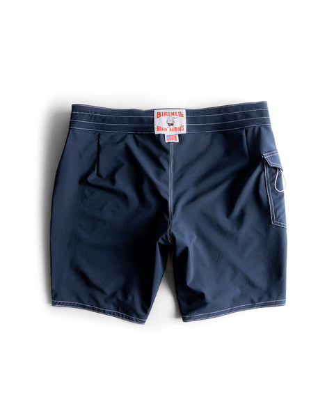 The 808 SurfStretch Side Pocket Boardshorts in navy, featuring white stitching, a back pocket with a loop, and a Birdwell label above the waistband, made in the USA, are shown on a white background.