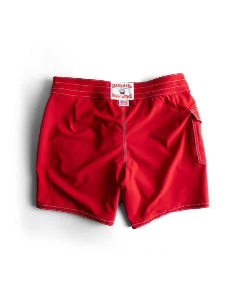 The 806 SurfStretch Side Pocket Boardshorts in bright red feature white stitching, a right rear pocket, and a white Birdwell label at the waistband. Made in the USA and shown on a white background.