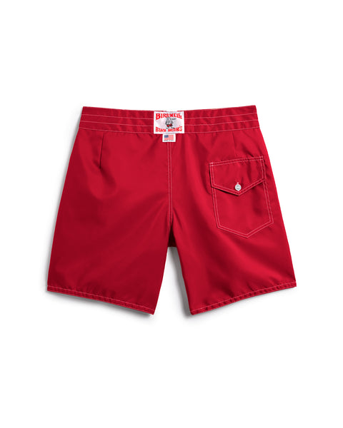 Back view of the 300 Boardshorts - Red, featuring white stitching, a right-side flap pocket with button, and a red and white label above the waistband. Made in USA. Set against a plain white background.