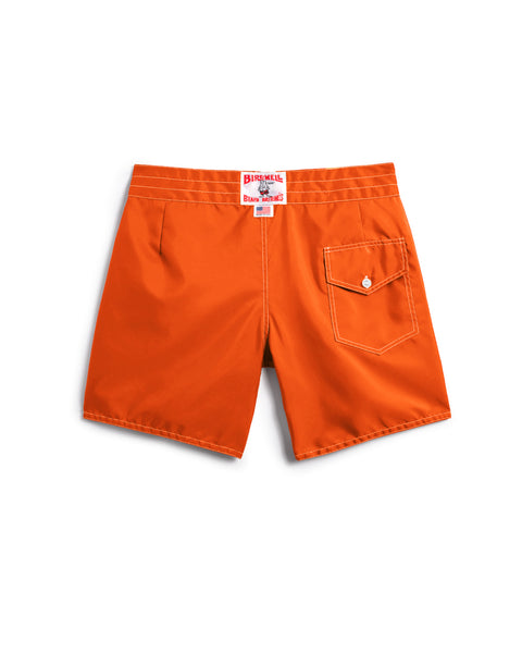 Medium orange 310 Boardshorts shown from the back, featuring a single right-side flap pocket with button, white stitching, and a white waistband label with red text.