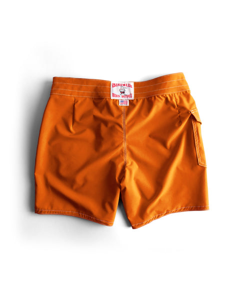 Medium orange 808 SurfStretch® Side Pocket Boardshorts, featuring a back pocket and a white and red Birdwell waistband label, made in the USA, shown flat against a white background.