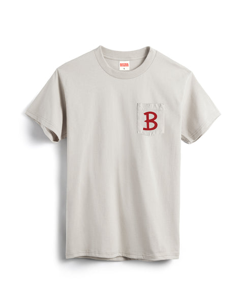The Script Pocket T-Shirt - Cement is a light gray, garment-dyed short sleeve shirt with a left chest cotton pocket featuring a large red letter B.