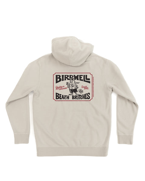 The Hangtag Midweight Hoodie - Bone is a light beige, relaxed fit hoodie with a large retro Birdwell Beach Britches graphic on the back, showing a cartoon surfing bird and bold black and red lettering.