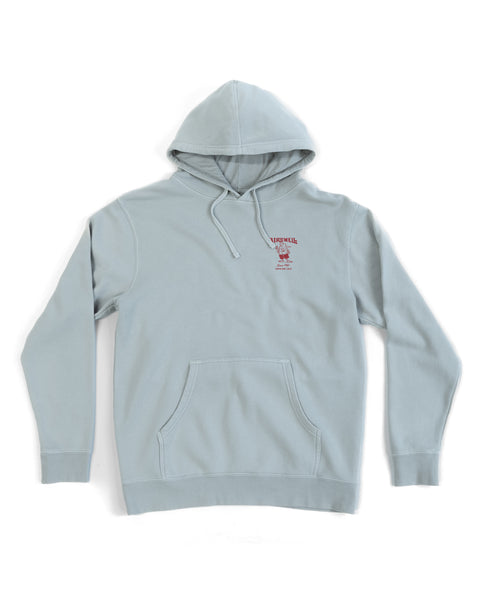 61 Midweight Hoodie - Sage: Relaxed fit in light sage with front pocket and drawstrings. Features a small red screen-print graphic with text on the left chest. Displayed laid flat on a white background.
