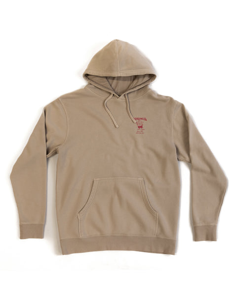 61 Midweight Hoodie - Sand: Relaxed fit, beige pigment-dyed hoodie with front pocket and drawstrings. Features a small red screen-printed text graphic on the left chest. Displayed flat on a white background.