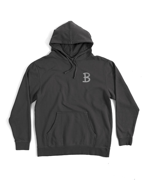 The Script Midweight Hoodie - Faded Black is a relaxed fit hoodie in plain black with a front pocket, drawstrings, and a light gray B logo screen-printed on the left chest. Displayed laid flat on a white background.