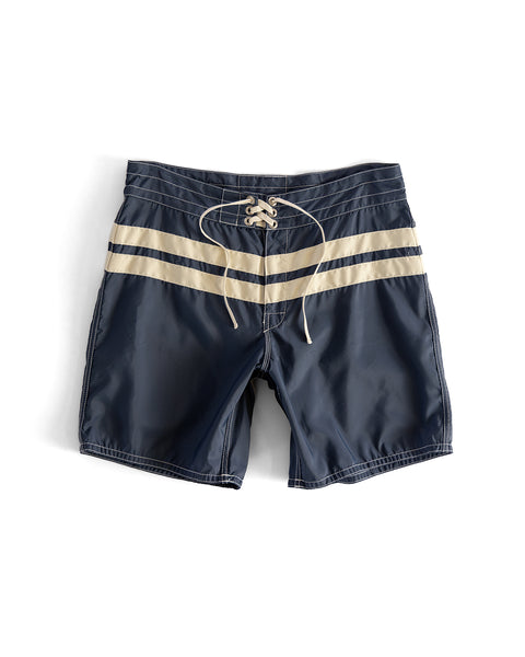 The 300 Comp Stripe - Navy/Bone boardshorts feature two horizontal beige stripes near the waist and a white lace-up drawstring at the front, all made in the USA.