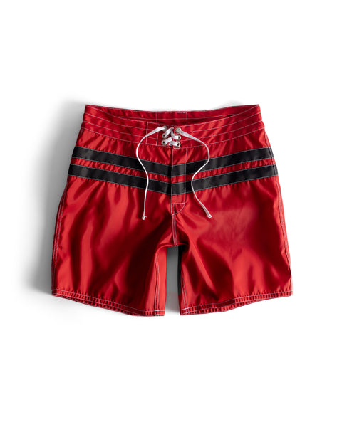 The 300 Comp Stripe - Red/Black boardshorts feature white drawstrings and two black horizontal stripes, crafted in the USA from durable SurfNyl fabric, shown on a white background.
