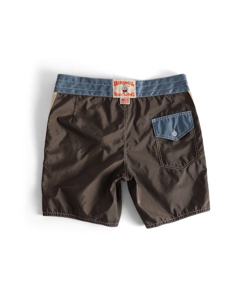 A pair of 300 Legend boardshorts in brown with a federal blue waistband, blue back pocket with button flap, and a Birdwell Beach Britches label—classic style made in the USA.