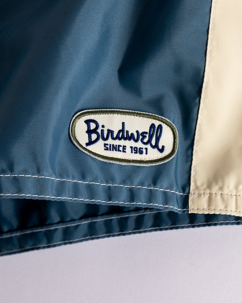 Close-up of the 300 Legend boardshorts in Federal Blue/Dark Olive/Bone, featuring an embroidered 