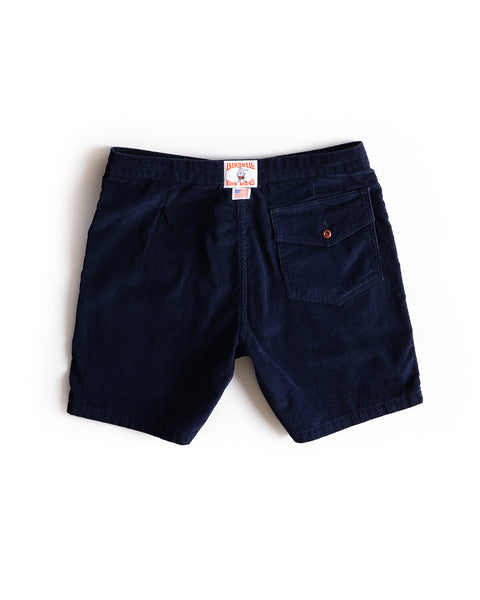 Classic Corduroy Shorts - Navy, laid flat to show the back, feature a right-side buttoned pocket, white and orange waistband tag, and an adjustable drawcord waist for a customized fit.