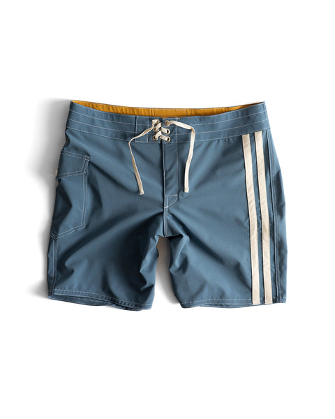 808 Racing Stripes boardshorts in Federal Blue/Bone, featuring a white drawstring, yellow interior lining, two vertical white side stripes, and a side pocket, displayed on a white background.