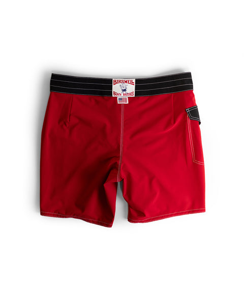 The 808 Mono Stripe - Red/Black boardshorts feature a black waistband, white stitching, a small side pocket, and Birdwell branding on the back. Made in the USA, these medium-length shorts are shown laid flat on a white background.