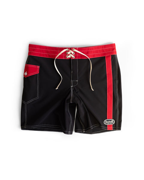 The 808 Mono Stripe - Black/Red is a black, medium-length boardshort featuring white stitching, a red waistband with red accents, white drawstrings, and a Birdwell patch on the lower right leg. Made in the USA for comfort and durability.