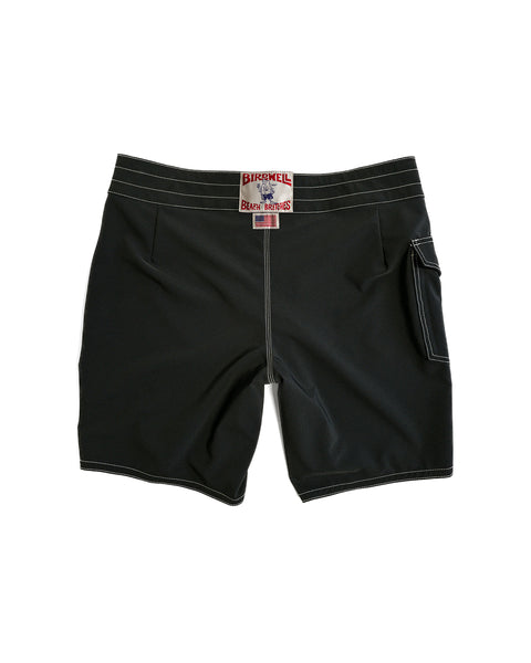 A pair of 808 Racing Stripes - Black/Olive medium-length board shorts with white stitching, a right-leg side pocket, and a red and white BIRDWELL BEACH BRITCHES label on the waistband, shown on a white background.