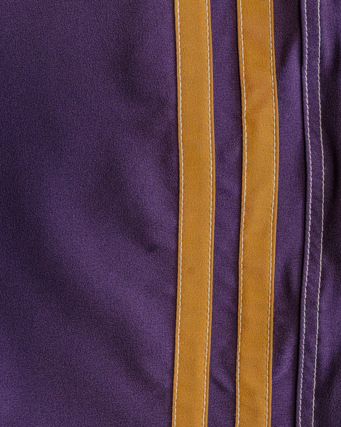 Close-up of 808 Racing Stripes - Purple/Gold: purple SurfStretch fabric with three gold stripes and white edge stitching. Made in the USA.