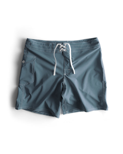 808 SurfStretch Side Pocket Boardshorts in Federal Blue with white drawstrings, side pocket, and white stitching, shown laid flat on a white background. Medium-length boardshorts made in the USA.