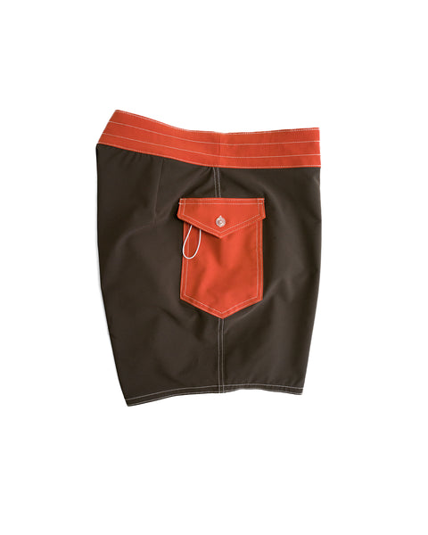 808 Pop Pocket boardshorts in Brown/Paprika, featuring an orange waistband, back pocket, white stitching, and a small white string loop. These water-repellent shorts are shown laid flat against a white background.