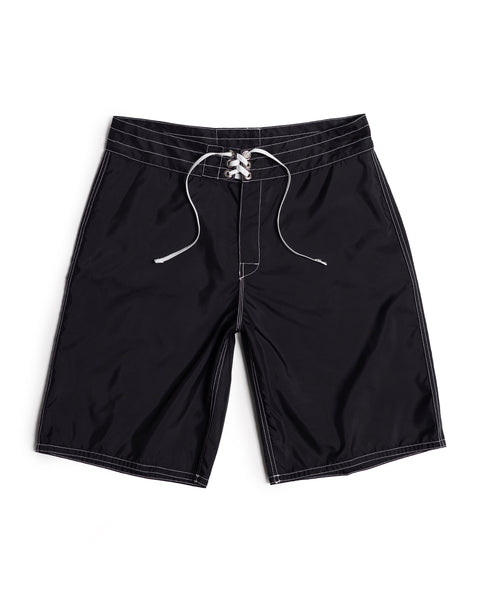 312 Boardshorts - Black, made in the USA from long-length SurfNyl fabric, featuring white stitching and a lace-up drawstring waistband, are laid flat on a white background.