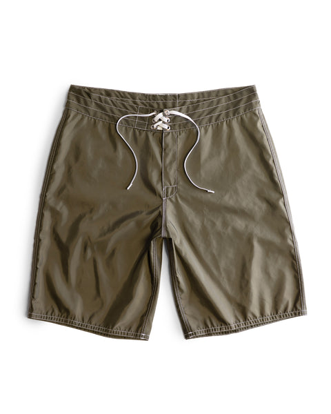 312 Boardshorts in Dark Olive are long-length boardshorts featuring a white drawstring closure, flat waistband, and visible stitching. Constructed from premium SurfNyl fabric and proudly made in the USA. Shown against a white background.