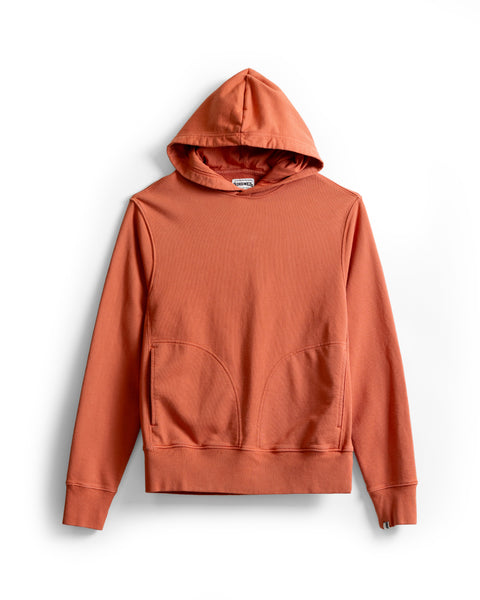 The Harmony Hoodie - Paprika is a premium hoodie in a rust-colored hue, crafted from soft French terry and featuring a hood, front pocket, and ribbed cuffs. Laid flat on a white background. Proudly made in the USA.