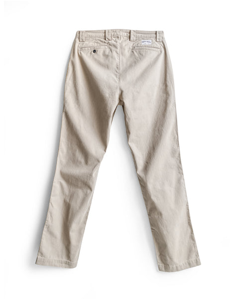 Stockman Chino Pants - Bone pictured from the back on a white background, showcasing two back pockets—one with a button and one with a small white label above it. Made in the USA from 100% cotton twill, these relaxed fit chino pants offer timeless comfort and quality.