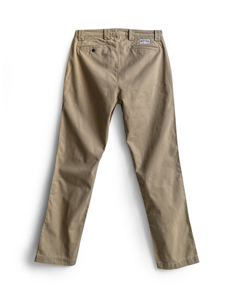 Stockman Chino Pants - Khaki shown laid flat on a white background, viewed from the back to highlight two back pockets (one with button closure), belt loops, and a small rectangular brand patch above the right pocket. Expertly crafted in the USA from cotton twill.